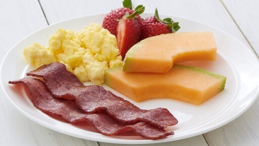 A simple meal with bacon and fresh fruits 